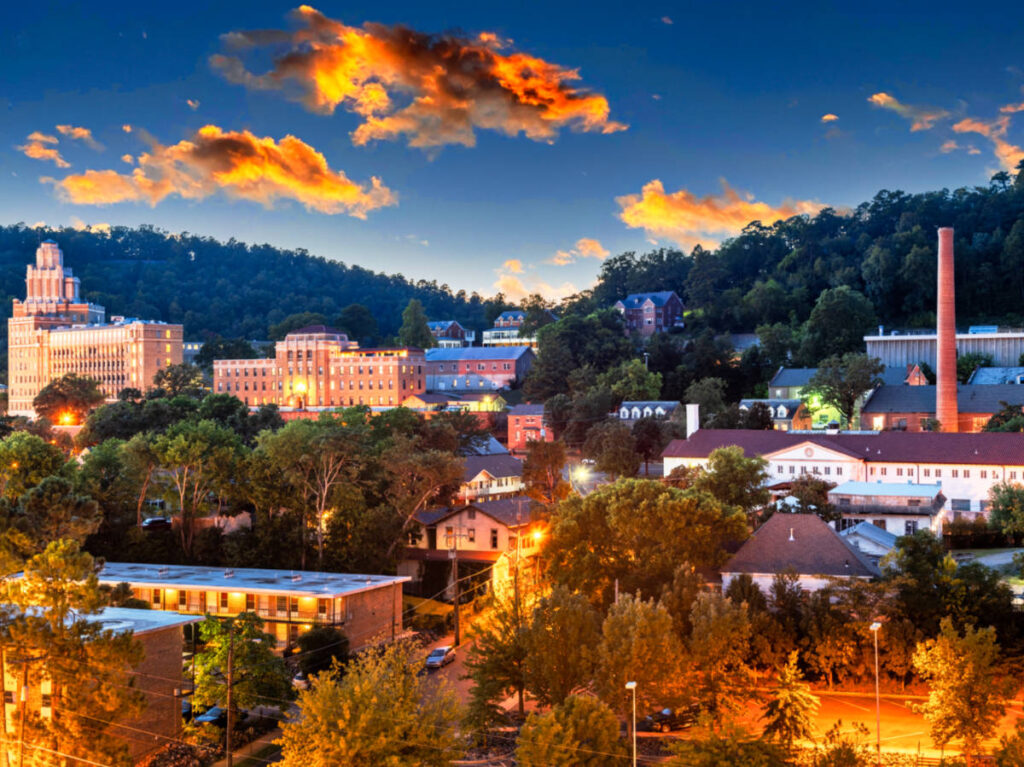 Aerial view of the townscape and lush mountains in the background at dusk