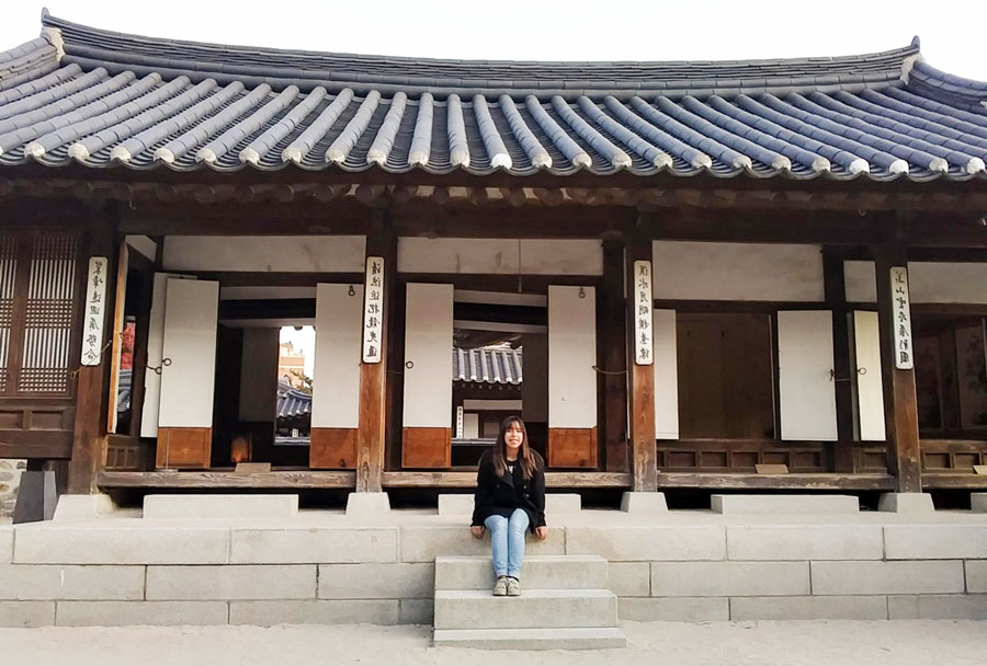 View of the author sitting in front of a Traditonal House in South Korea