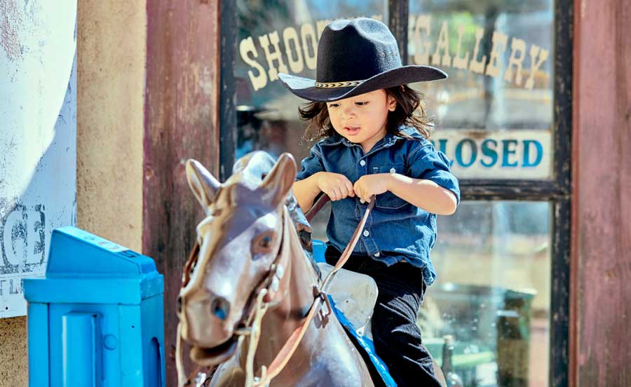 A little boy riding a mechanical horse toy in Trail Dust Town