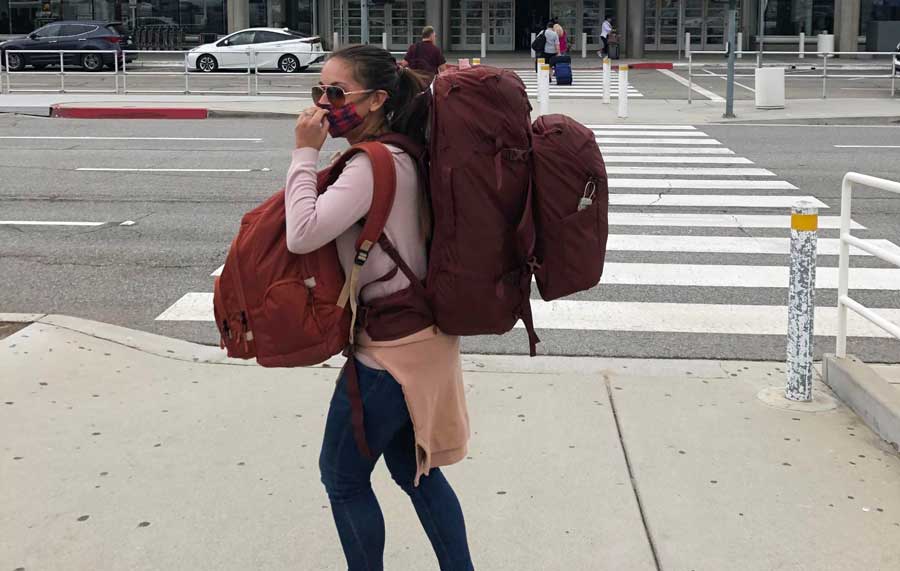 The author's sister carrying her over-packed travel backpacks