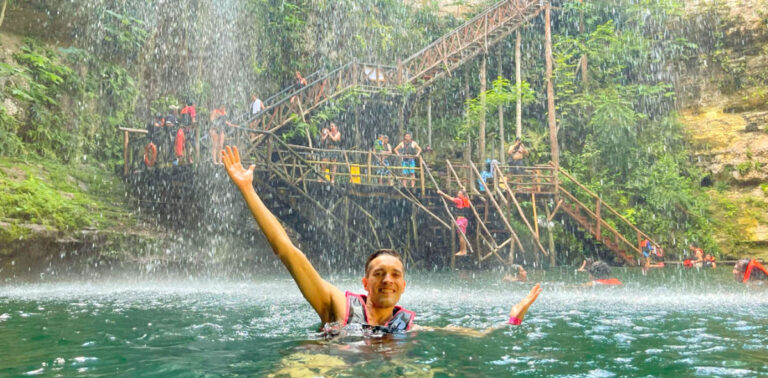 View of Nate posing for a picture while on the blue green water