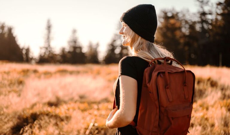 View of a woman wearing a beanie and a backpack, one of the best travel gifts for her