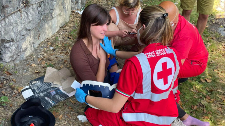 Travel Lemming Author Betty being treated by paramedics on a roadside in Italy