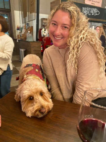 Travel Lemming Author Jess smiling brightly with her dog at Witch Creek Winery