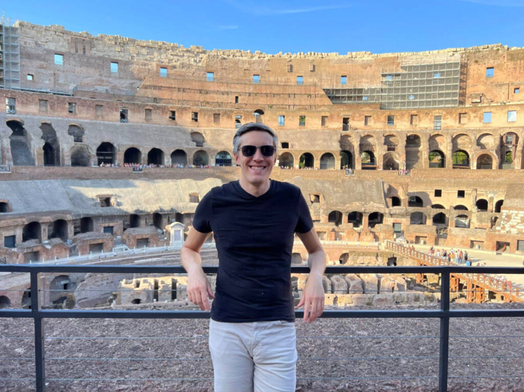 Travel Lemming Author Nate poses in front of the Coliseum arena
