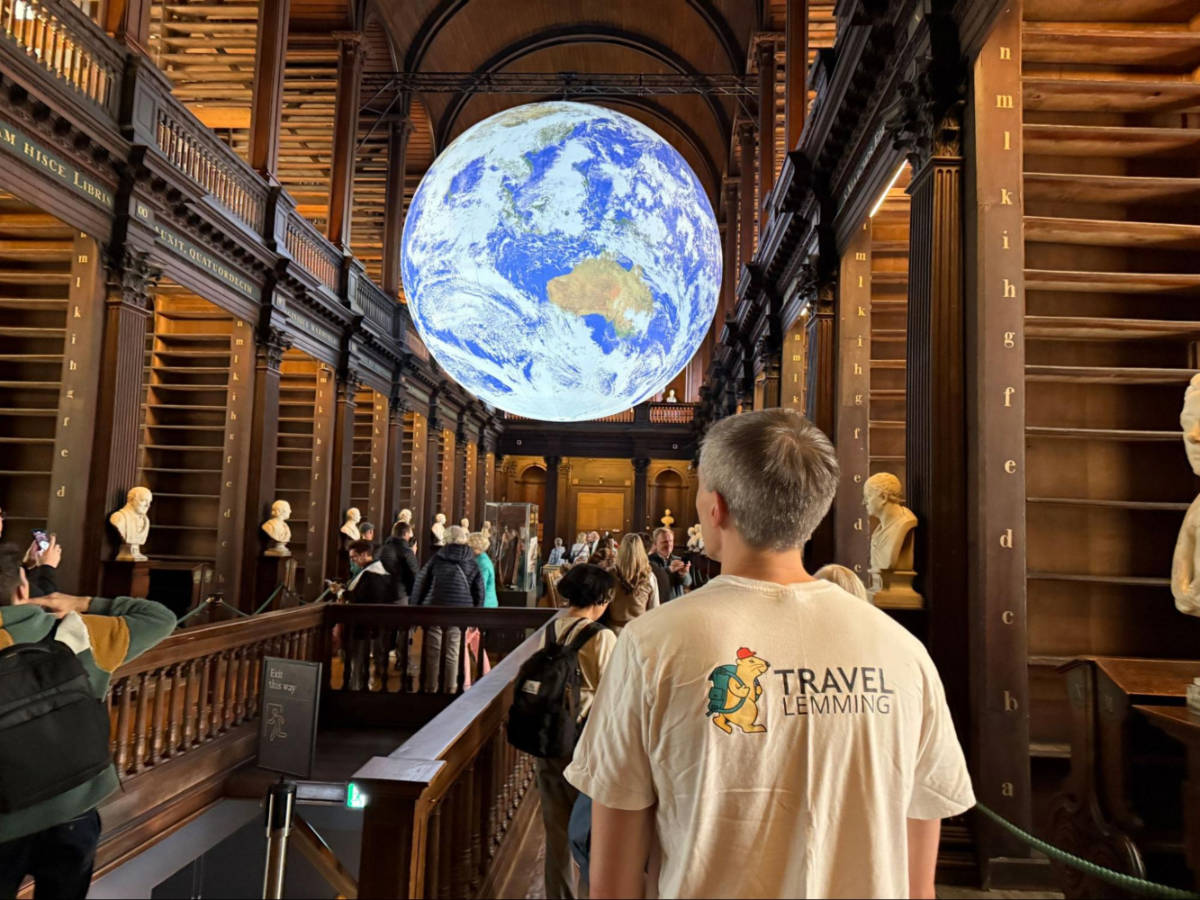 Travel Lemming founder Nate looking at the globe in the Trinity College Long Room
