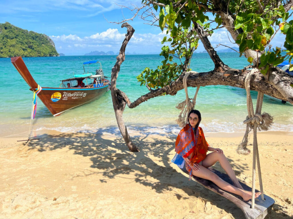 Travel Lemming writer Clara relaxing on a swing by the sea at Koh Phakbia