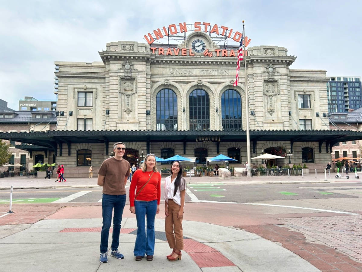 Travel Lemming Nate Hake, Laura Falin, and Abigail Bliss, posing for a photo in front of the Union Station