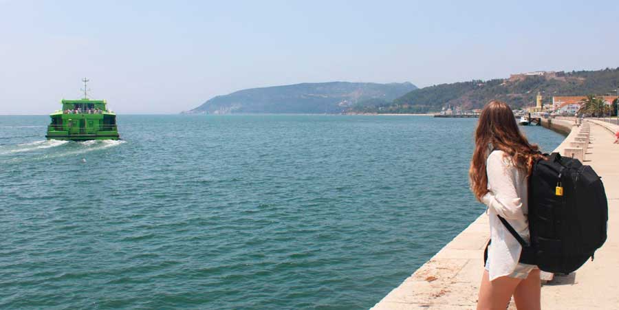 The author looking at the ocean in Portugal while carrying her Topo Designs Global Travel Bag
