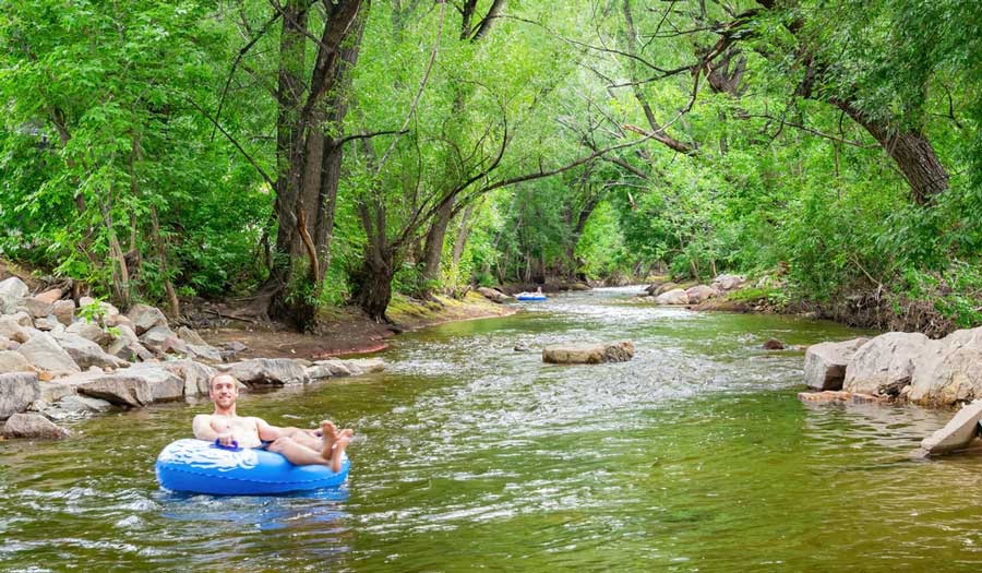 A man enjoying tubing on Boulder Creek