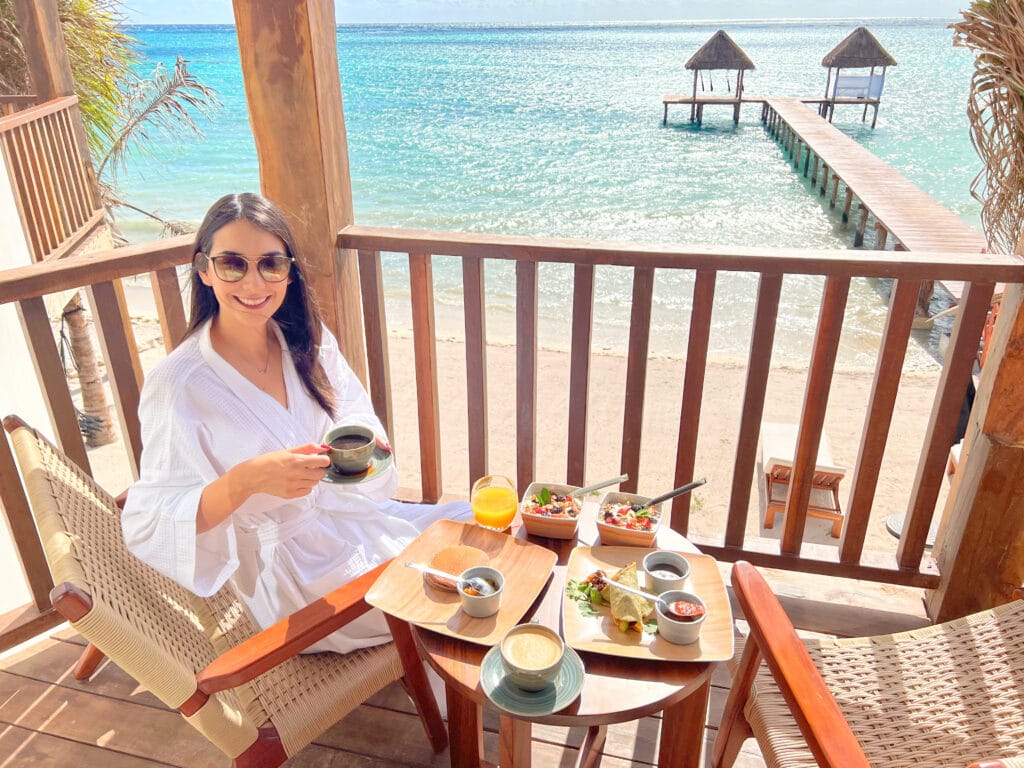 Clara enjoying breakfast overlooking the beach on a private hotel balcony