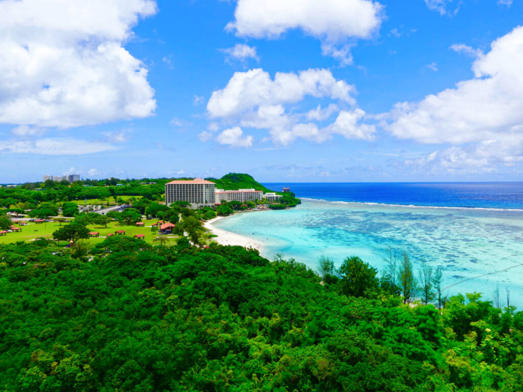 Aerial view of the clear blue waters and the greenery around the Tumon Bay