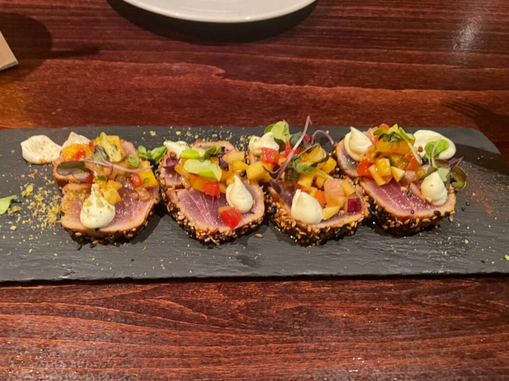 A Tuna tataki on a wooden board served on a restaurant in Barcelona