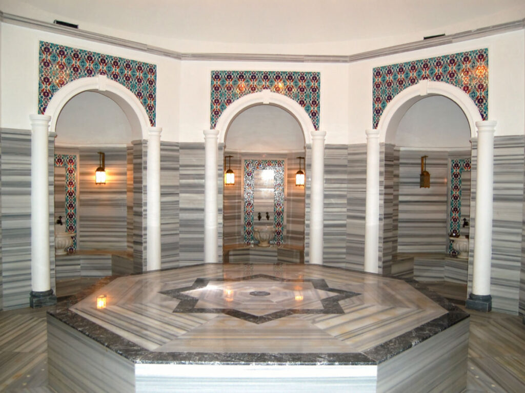 A spacious room with a marble floors featuring a hot stone in a traditional Turkish hammam