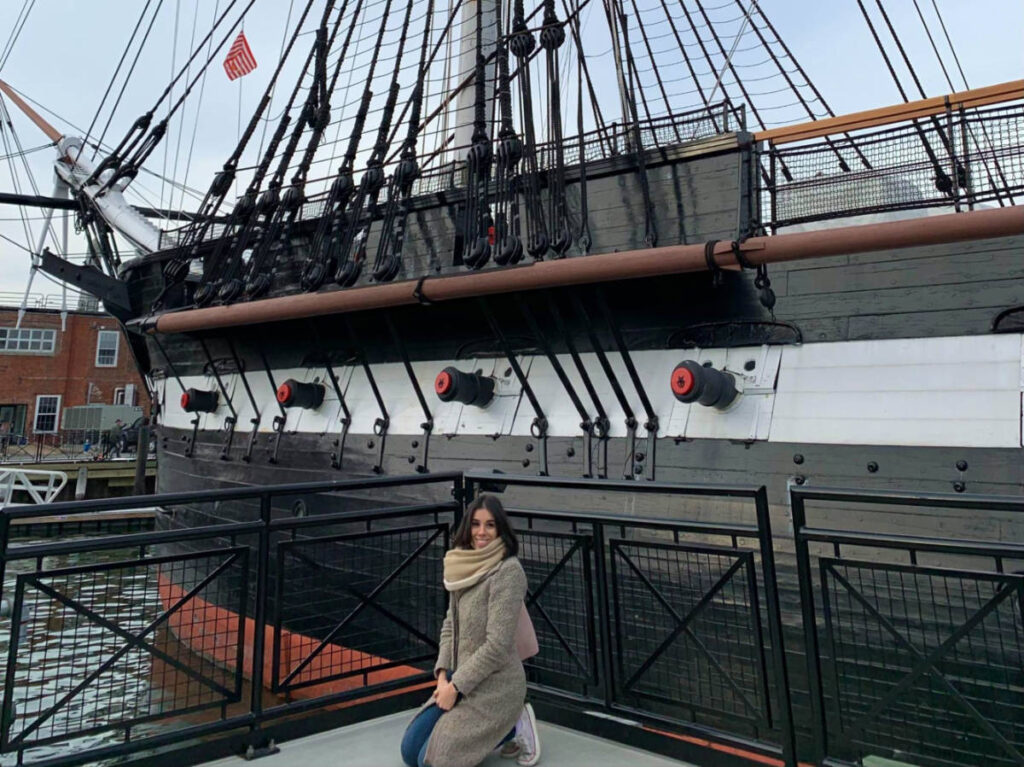 Author Claudicet Pena infront of the USS Constitution Museum