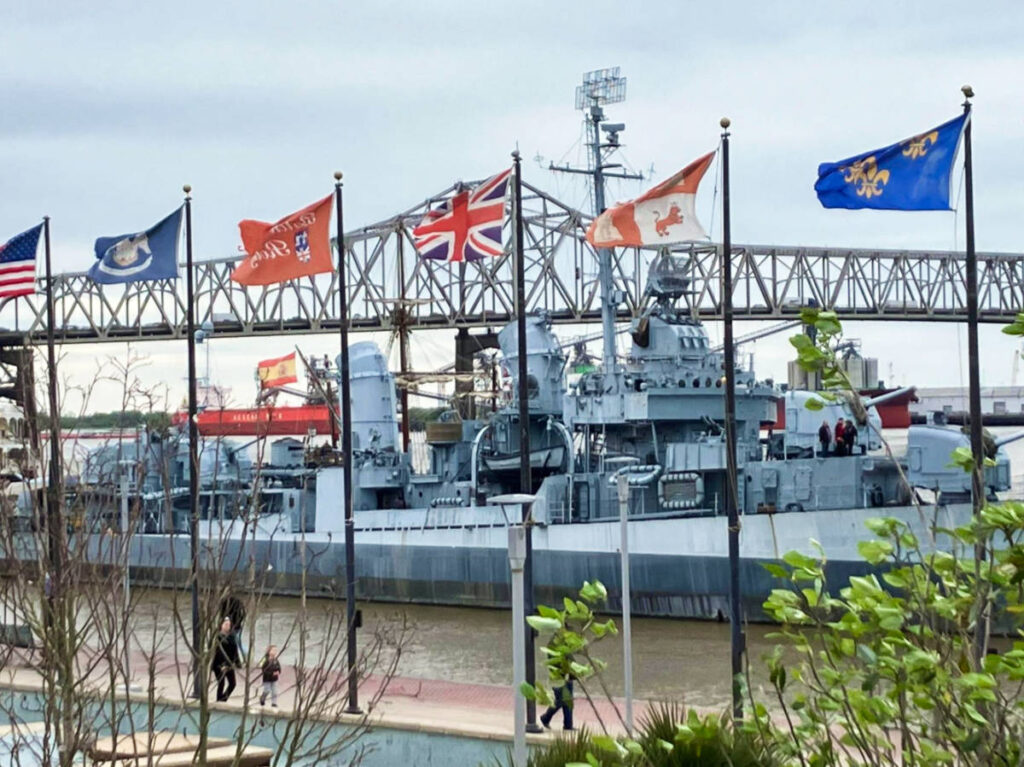 View of the USS Kidd Veterans Museum behind the lined flags on the poles
