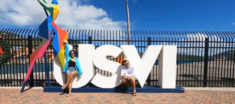 The author and his wife posing for a photo with the USVI sign