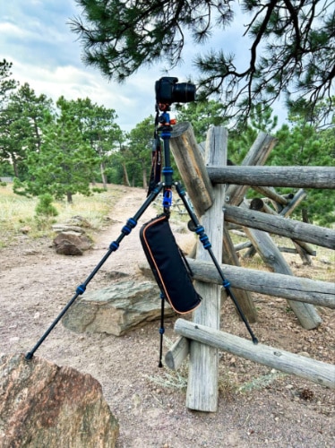 A DSLR mounted on the 3 Legged Thing Punks Corey 2.0 with a counterweight on uneven terrain