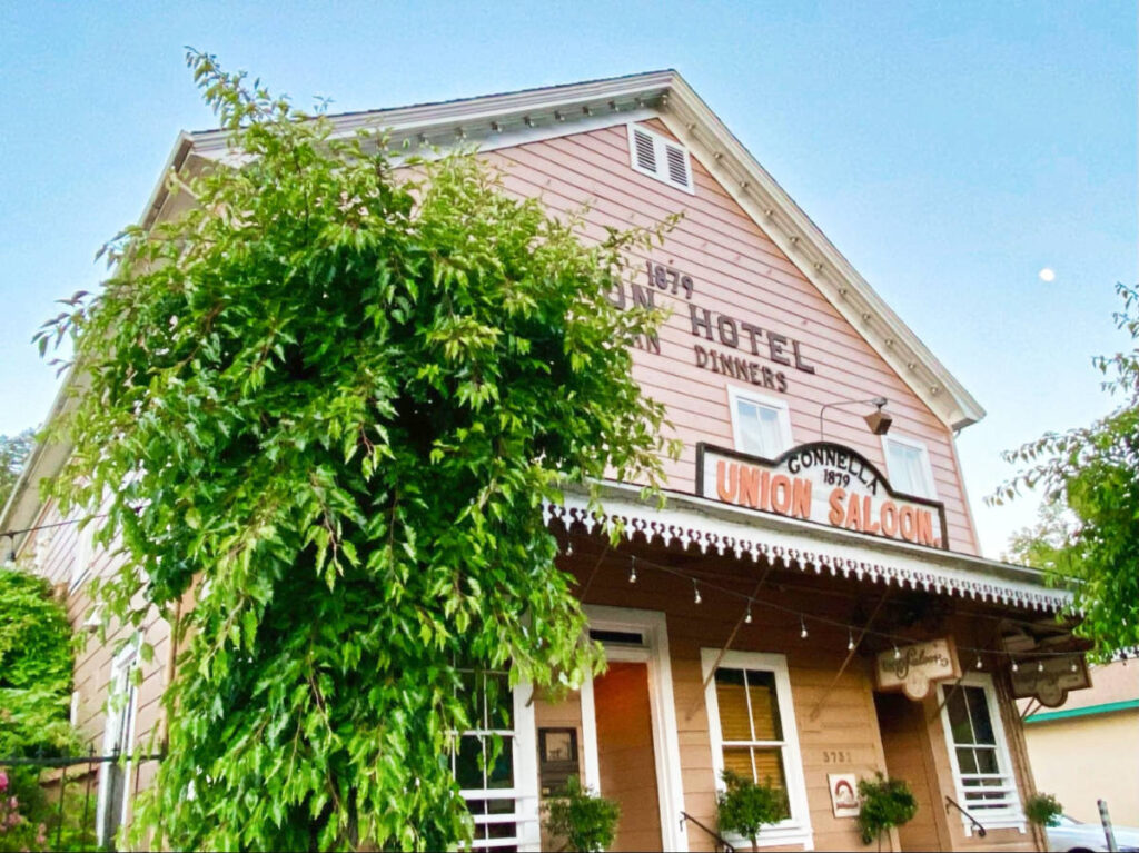 Exterior view of the Union Hotel in Occidental with a lush tree in the front
