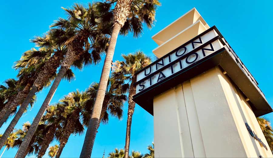 The Union Station and some palm trees under the clear blue sky in Downtown LA