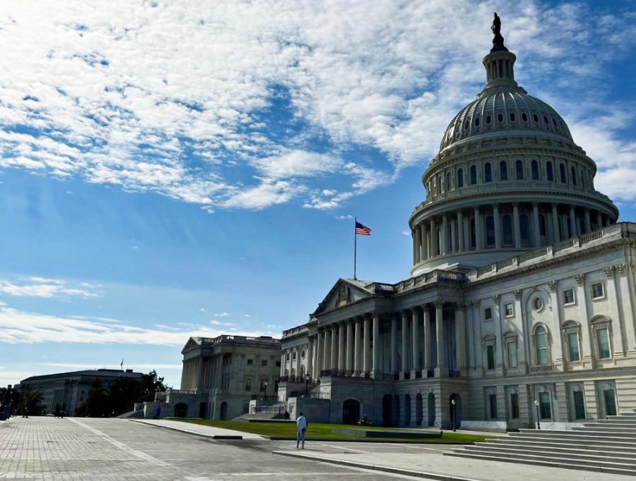 Exterior view of the United States Capitol from a distance on a sunny day