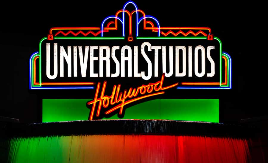 The glowing Universal Studios Hollywood sign with flowing water on it at night