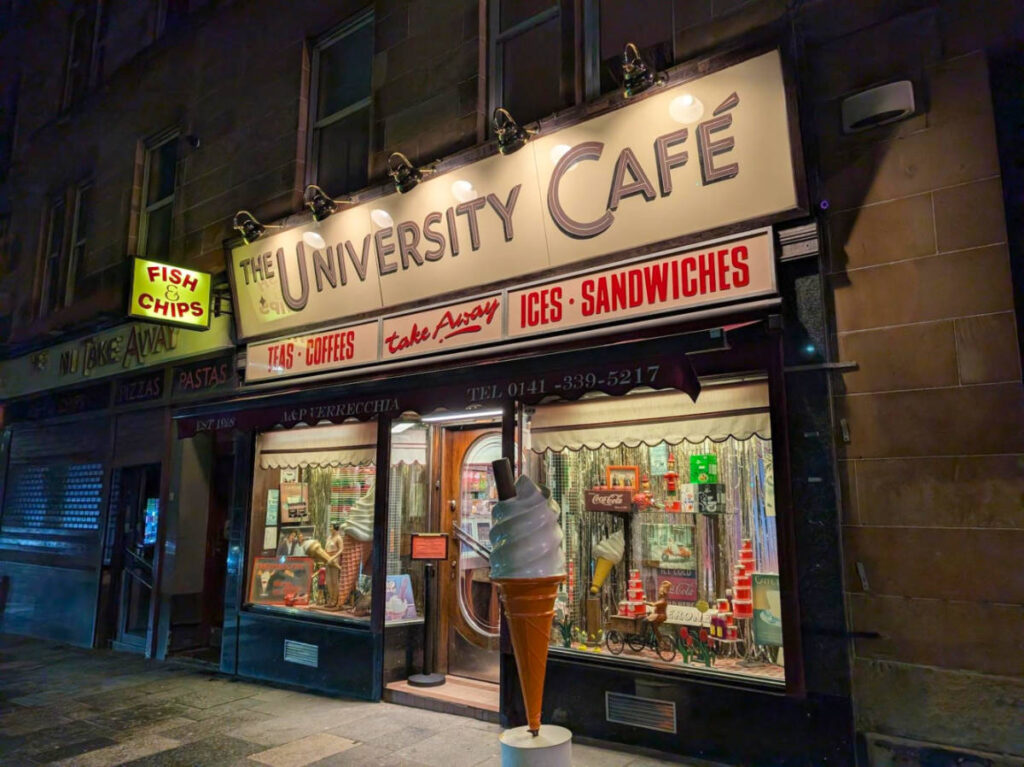 View of the storefront of University Cafe illuminated at night