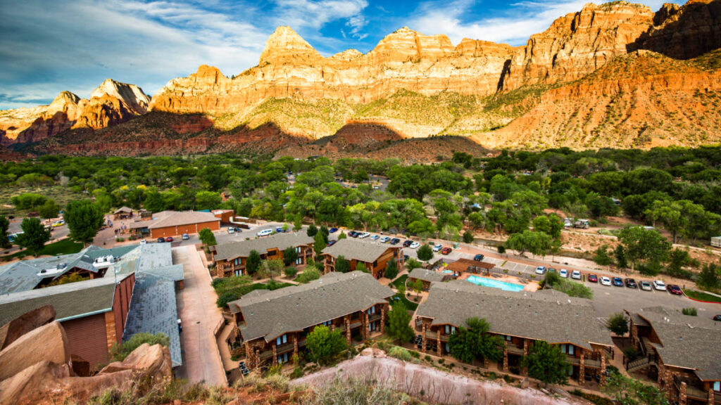 Aerial view of a town surrounded by towering red rock formations at sunset