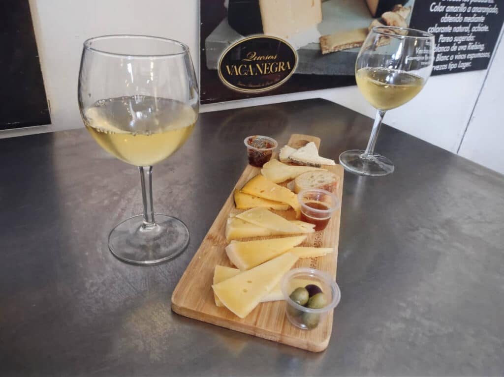 A cheese board and glasses of wine on a table in Vaca Negra