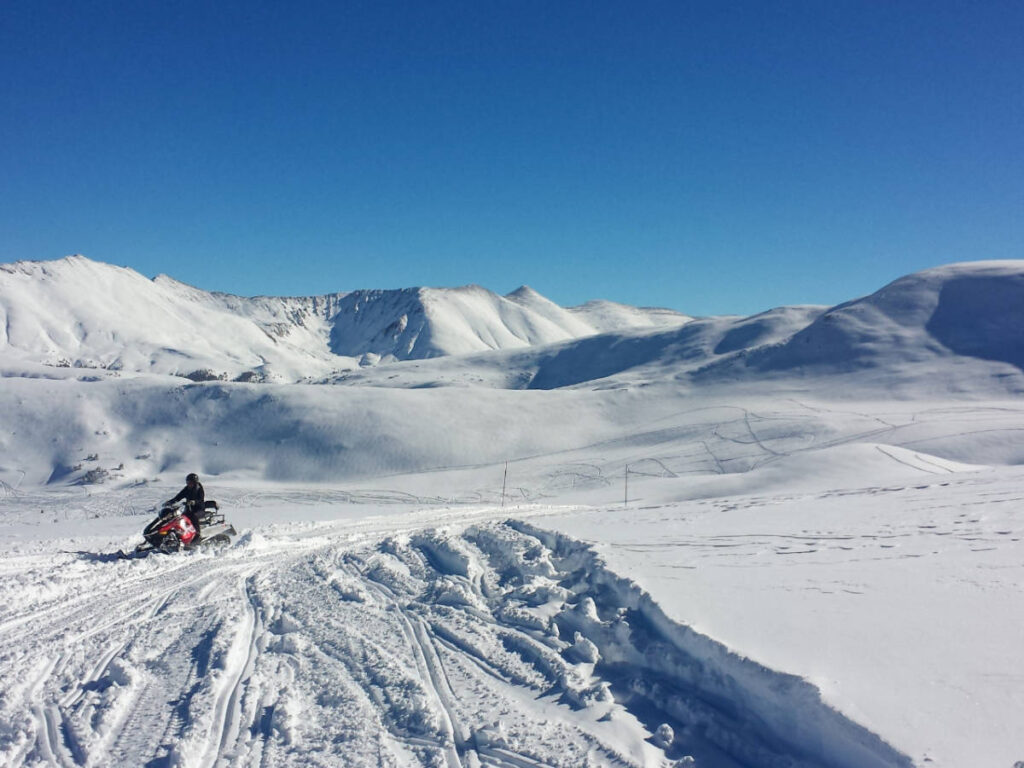 Snowmobiling at the Vail Mountain under the clear blue sky