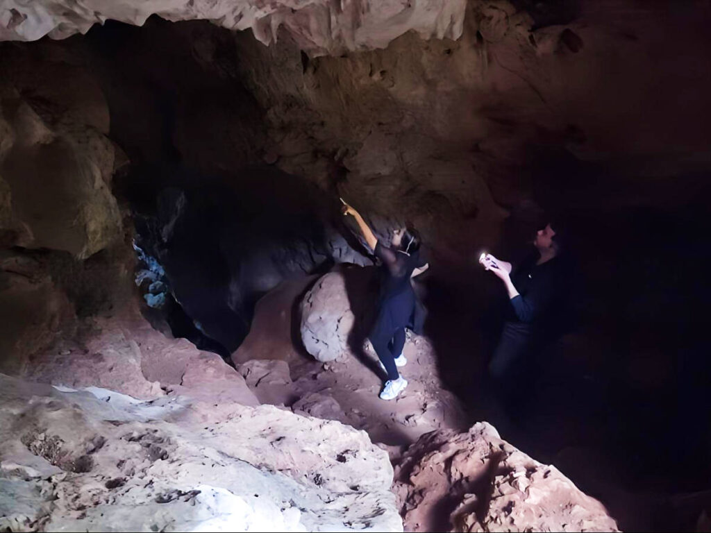 The author Vanessa pointing inside the cave