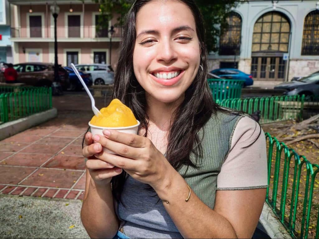 The author Vanessa Ramos, smiling for a photo while holding a cup of Passionfruit ice cream from King’s Cream