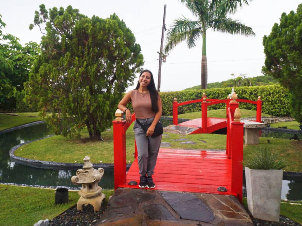 The author Vanessa Ramos, posing on the red bridge at the Japanese Garden in Ponce