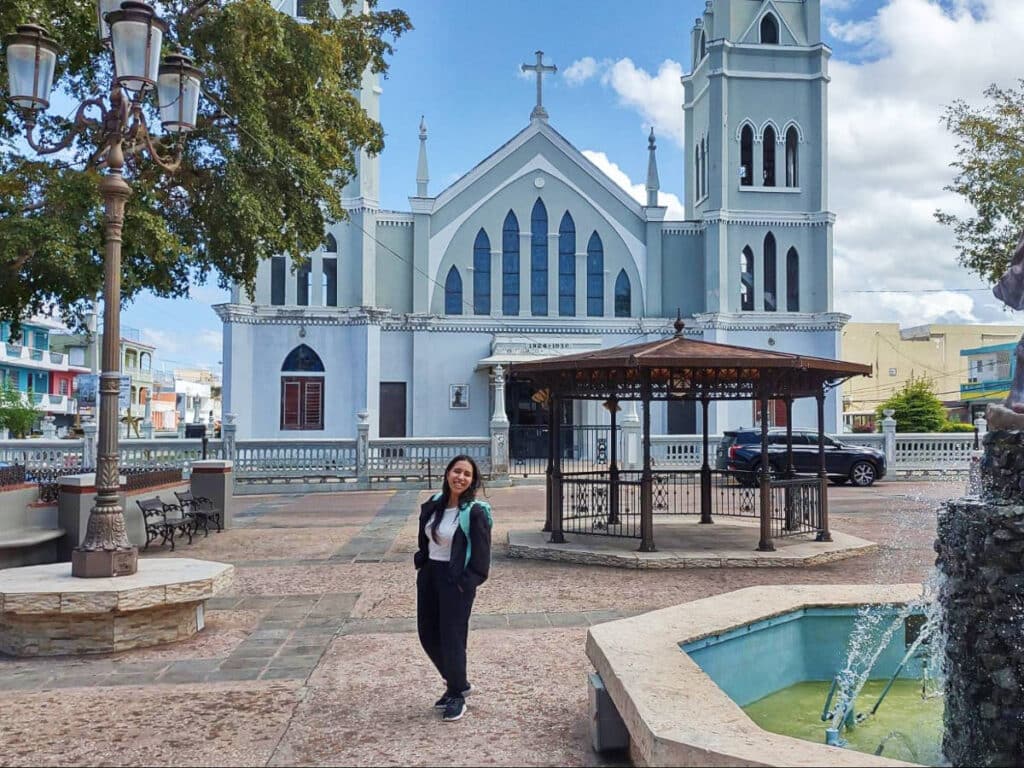 The author, Vanessa Ramos posing for a photo in front of a church in Aguada