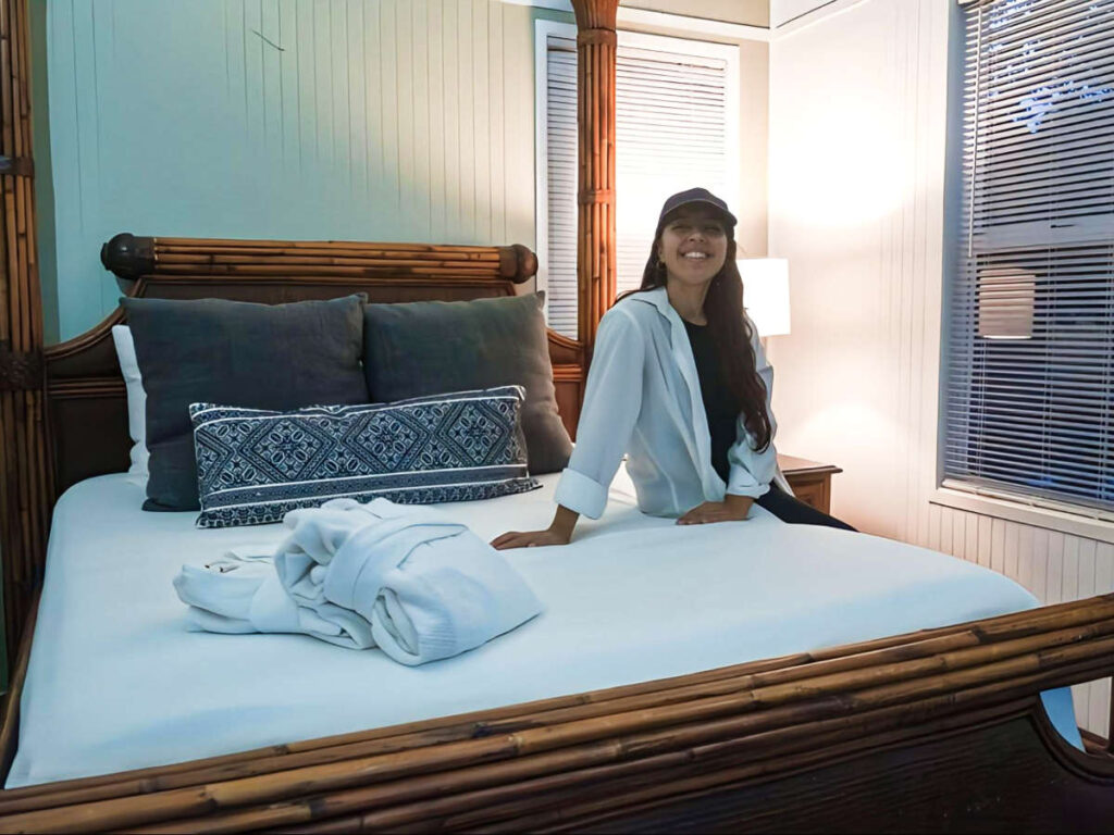 The author Vanessa Ramos, sitting on the bed in Club Seabourne Hotel