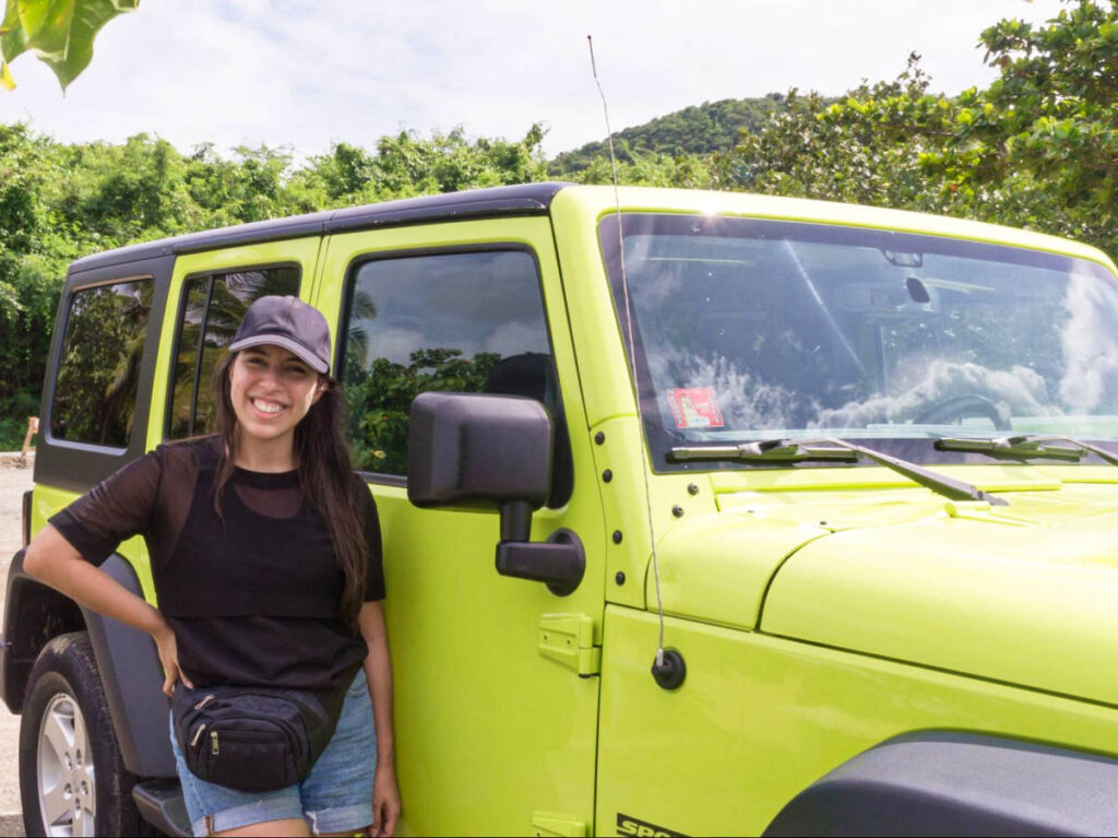 The author Vanessa Ramos, posing beside the green 4x4 vehicle
