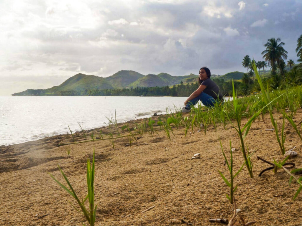 The author Vanessa Ramos sitting watching the beach view
