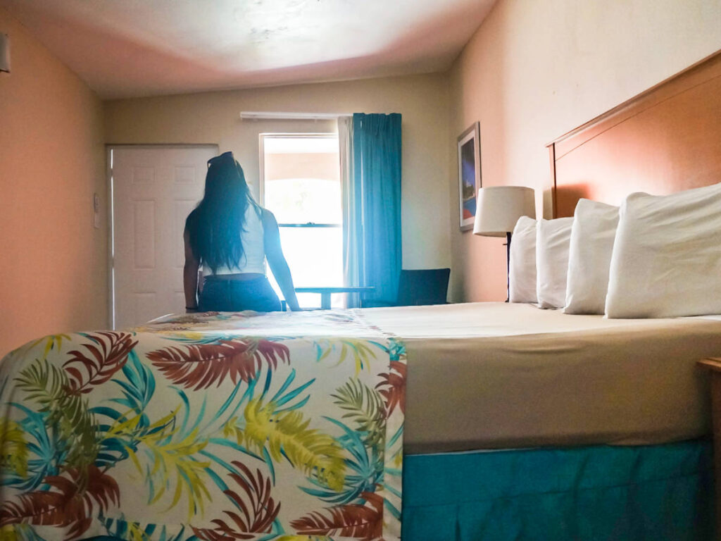 The author Vanessa Ramos sitting on the bed in Parador MaunaCaribe in Maunabo