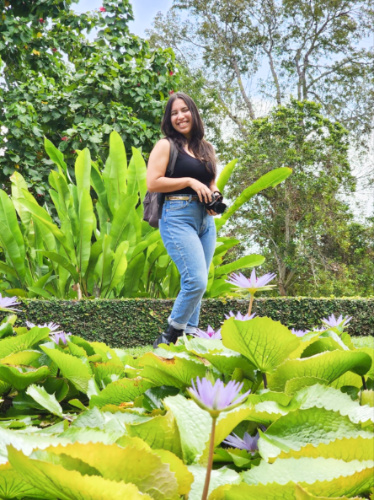 The author Vanessa Ramos, posing for a photo near the lotus pond in Caguas Botanical Garden