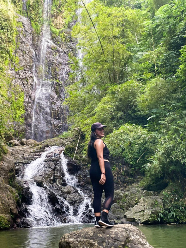 The author Vanessa Ramos, posing in front Charco Prieto while standing on a rock
