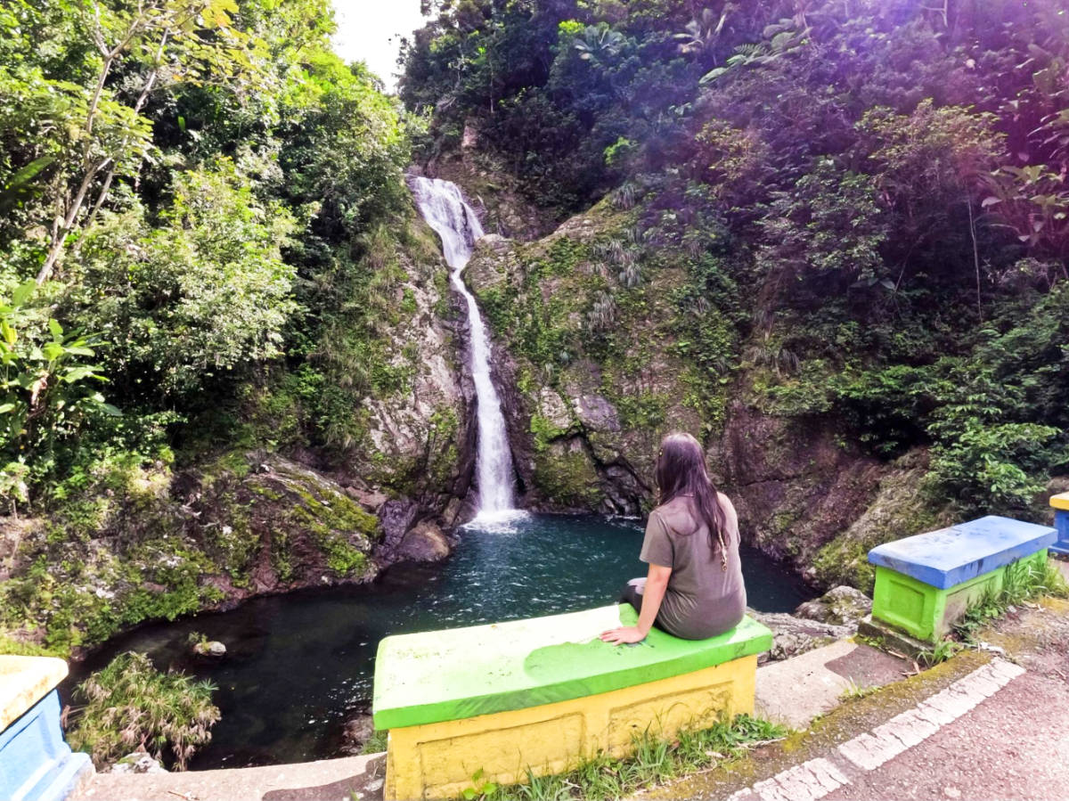 The author Vanessa sitting in front and admiring the Doña Juana Waterfall