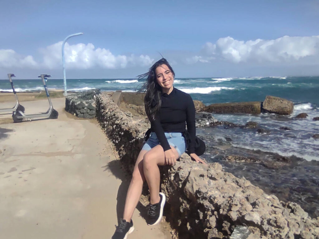 The author Vanessa Ramos sitting near the Escambrón Beach on a sunny day