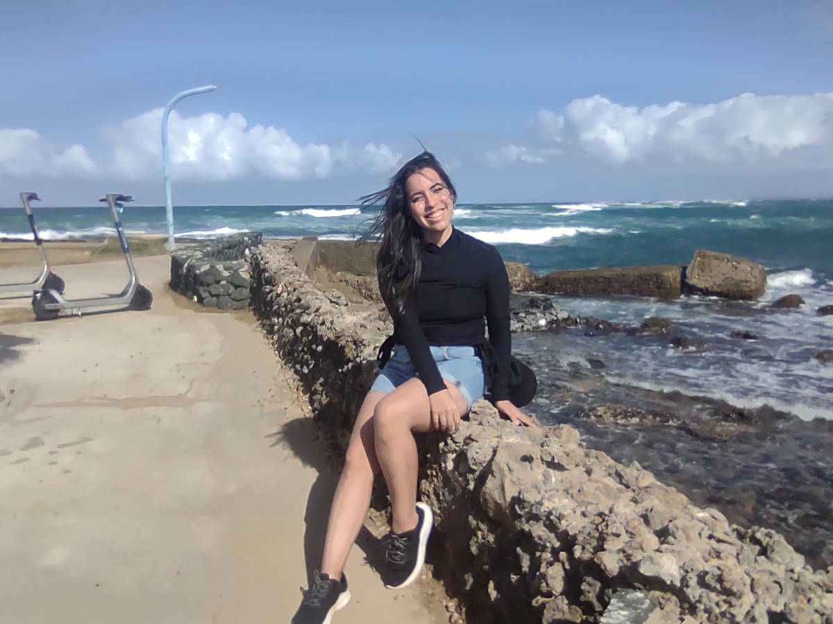 The author Vanessa Ramos sitting near the Escambrón Beach on a sunny day