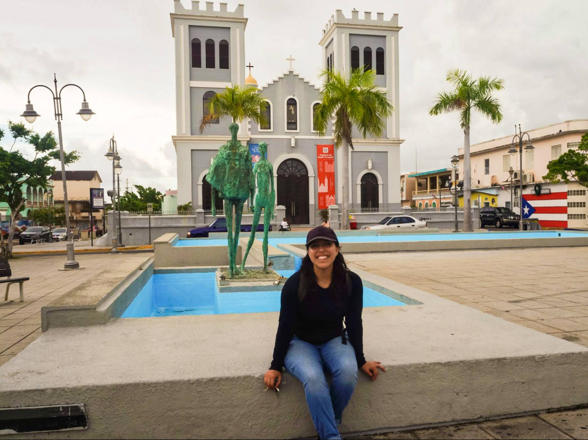 The author Vanessa Ramos, sitting near the fountain at Isabela’s Plaza