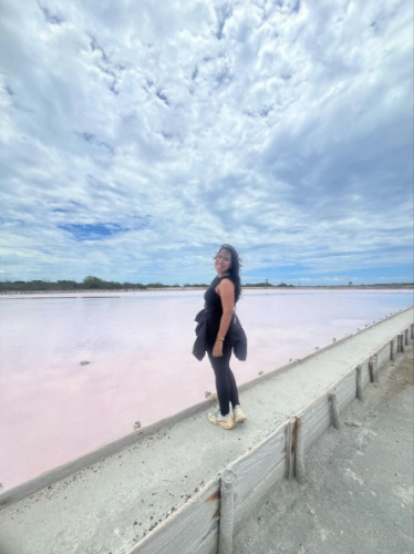The author Vanessa Ramos posing for a photo with the vas view of the pink salt in Las Salinas