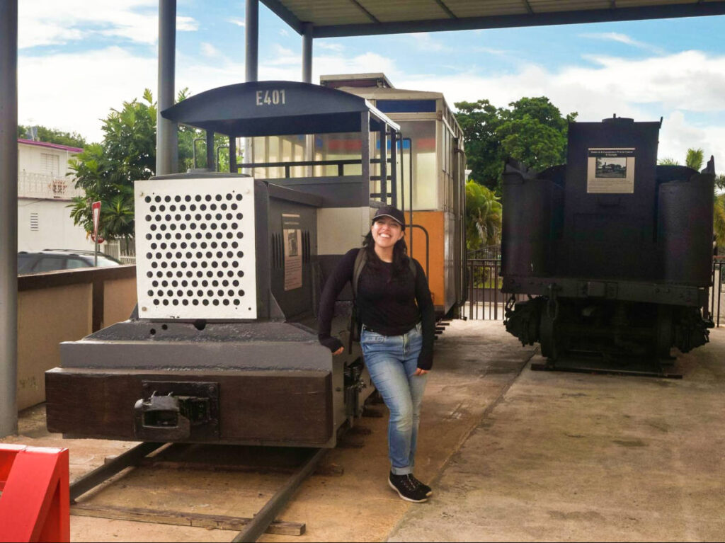 The author Vanessa Ramos, standing next to a train at the at Museo del Tren