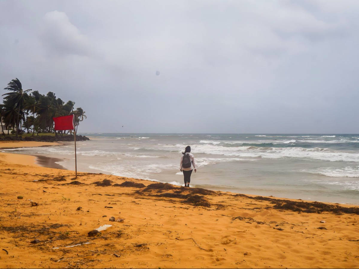 The author Vanessa admiring the strong waves and wind at Playa La Pared on a gloomy day