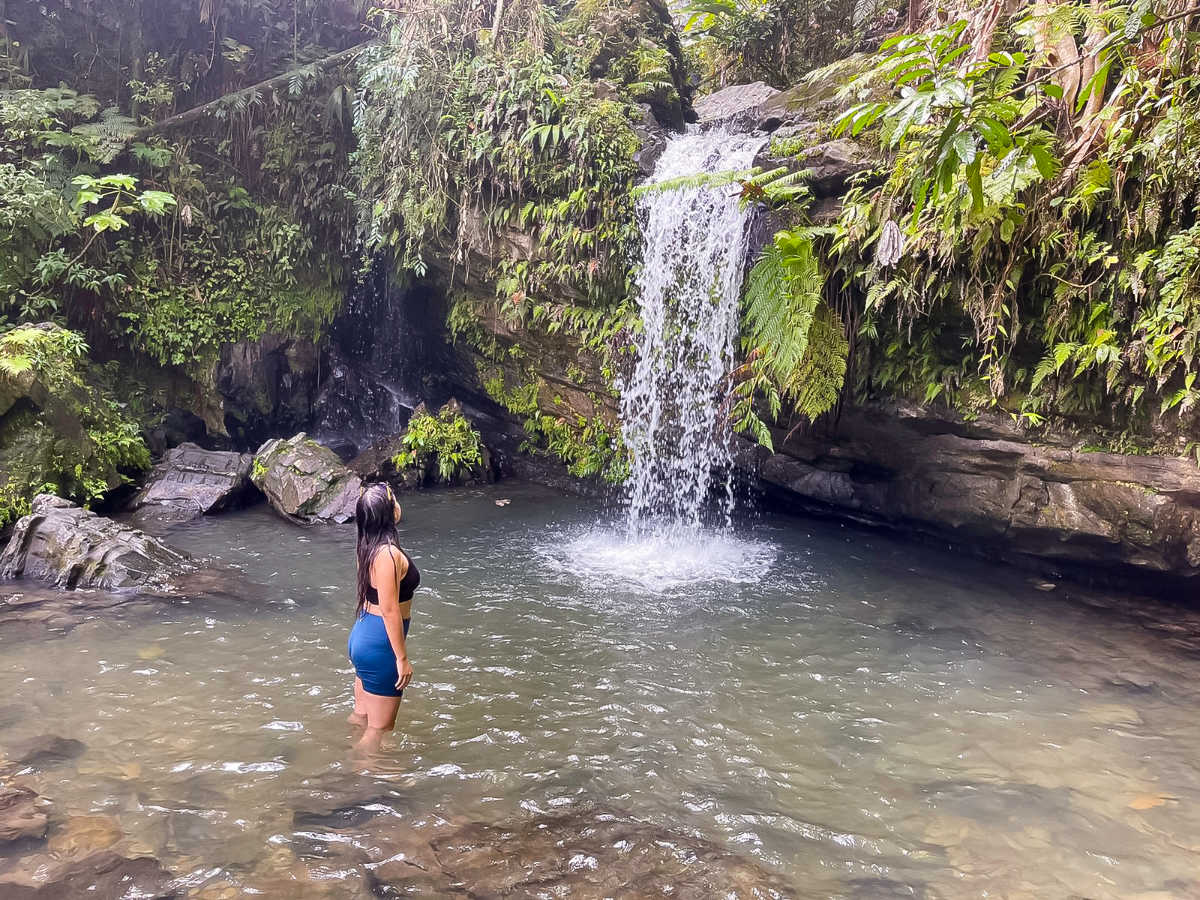 The author Vanessa Ramos looking up to the Juan Diego Waterfall