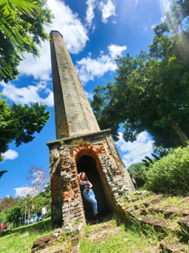 The author Vanessa Ramos, posing for a photo under the plantation ruins