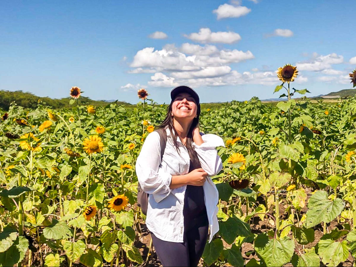 The author Vanessa Ramos, posing for a photo in front of the sunflower field in Finca Girasol